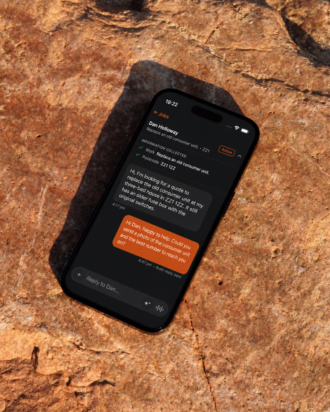 Tragent replying to a customer enquiry on a phone resting on rock