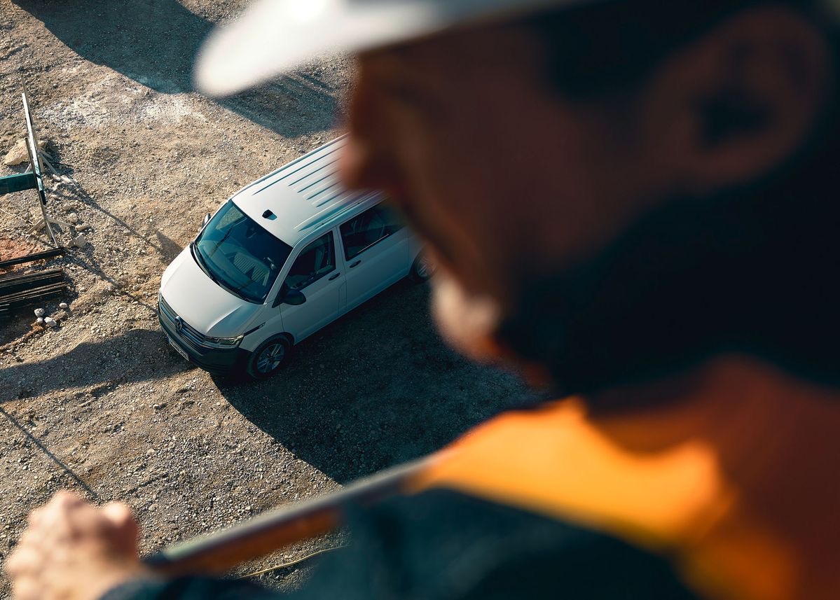 Tradesperson looking down over a work van on site